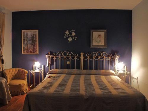 a bedroom with a bed with a blue wall at Hotel Rural Posada Los Caballeros in Almagro
