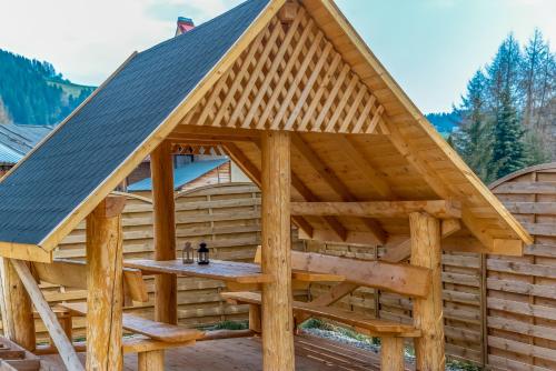 a wooden gazebo with a table in it at Domek w Białce z JACUZZI w ogrodzie in Białka Tatrzanska