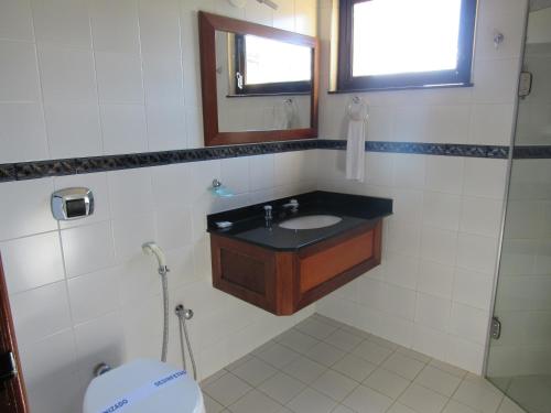 a bathroom with a sink and a mirror at Alfenas Palace Hotel in Alfenas