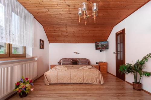a bedroom with a bed and a wooden ceiling at Pension Danninger in Piešťany