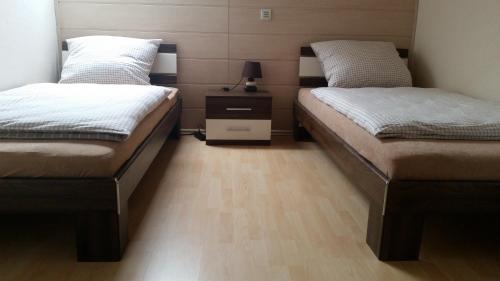 2 łóżka pojedyncze w pokoju z drewnianą podłogą w obiekcie Gästezimmer Langenselbold w mieście Langenselbold