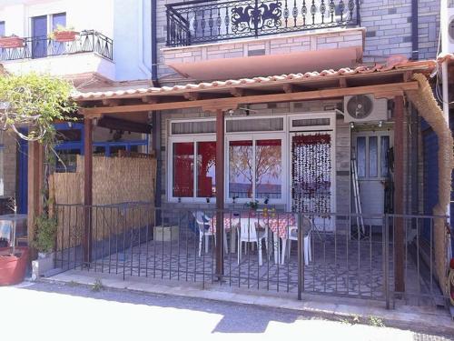 patio ze stołem i krzesłami poza budynkiem w obiekcie Gatos Apartment w mieście Skala Marion