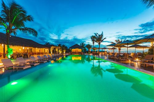 a swimming pool with chaise lounges and chairs at a resort at Manati in Barra Grande