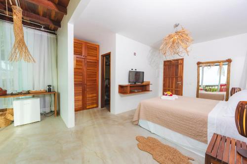 a bedroom with a bed and a tv in it at Manati in Barra Grande