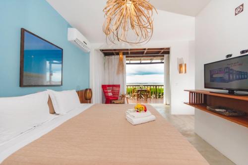 a living room with a couch and a tv at Manati in Barra Grande
