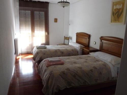 um quarto com 2 camas e uma janela em Somonte Costa em Santander