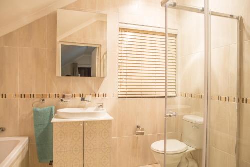 a bathroom with a toilet and a sink and a shower at The Living Collective - The Gates in Hilton