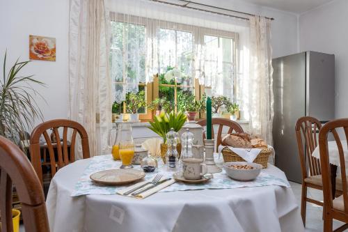 a dining room table with a white table cloth and a table at Pension Danninger in Piešťany