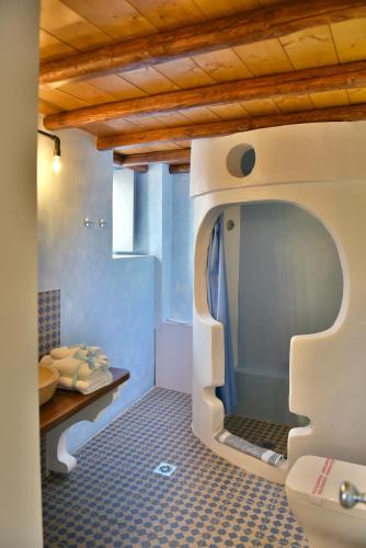 a bathroom with a toilet in the middle of a room at Manolia in Hydra