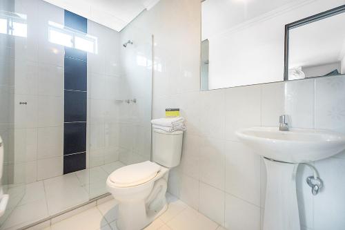 a white bathroom with a toilet and a sink at Ayenda 1219 Park 6 in Medellín