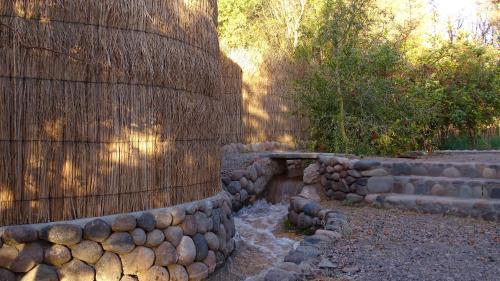 a garden with a retaining wall and a bench at Naturalis Hotel in San Pedro de Atacama
