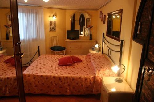 a bedroom with a bed and a television in it at Parco Delle Tre Fontane in Nicolosi