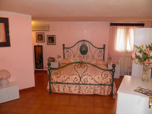 a bedroom with a bed in a room with pink walls at Parco Delle Tre Fontane in Nicolosi