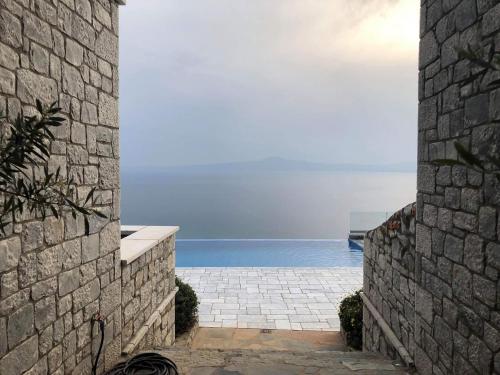 a stone wall with a view of the ocean at Petra Thea in Kalamata