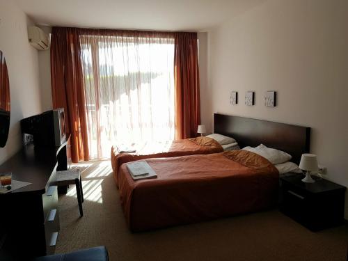 una camera d'albergo con due letti e una finestra di Sunny Apartment relax & spa a Burgas