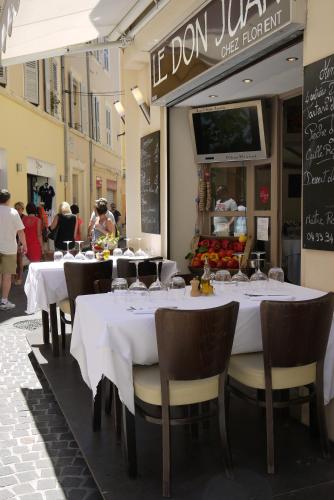 un restaurant avec des tables et des chaises blanches dans une rue dans l'établissement Vieille Ville 1 - Luca's Apartment, 1 bedroom, max 2 adults and 2 kids, à Antibes