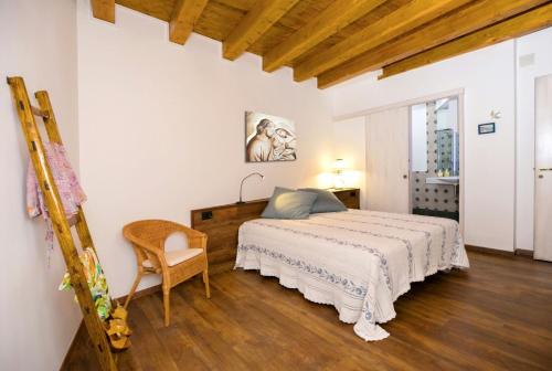 a bedroom with a bed and a chair at Casa di Nonno Mariano in Motta Camastra