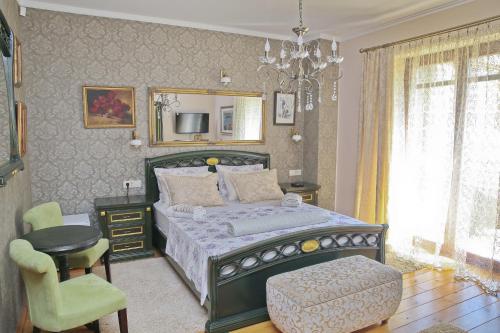 a bedroom with a bed and a chair and a chandelier at Palazzo Banicevic Luxury Rooms in Kotor