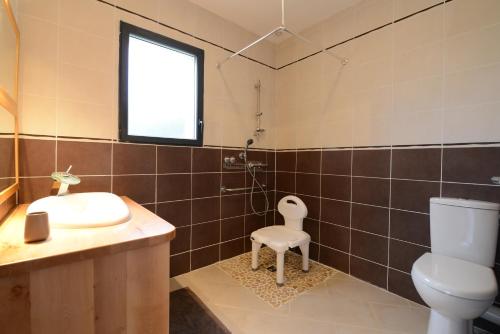 uma casa de banho com um lavatório, um WC e uma janela. em Lauz'oustal em Montrodat