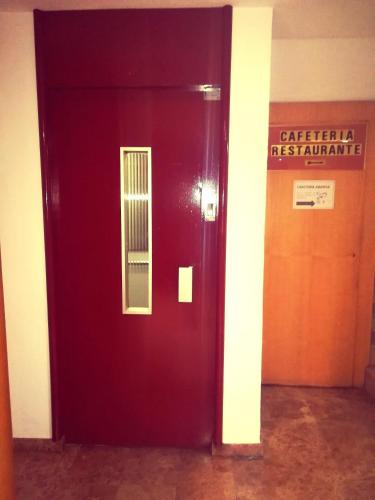 a red door in a building with a sign on it at Hotel Restaurante Logasasanti in Andújar