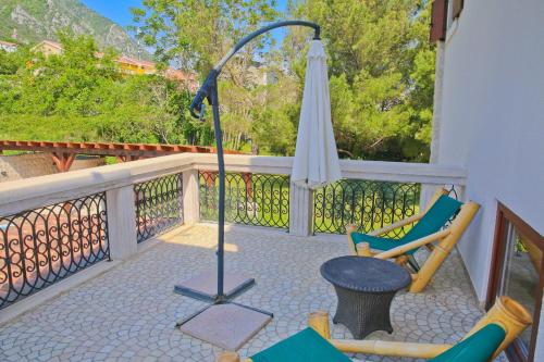 a patio with an umbrella and a chair and a table at Palazzo Banicevic Luxury Rooms in Kotor