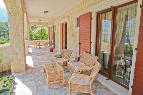 a patio with wicker chairs and a table at Palazzo Banicevic Luxury Rooms in Kotor