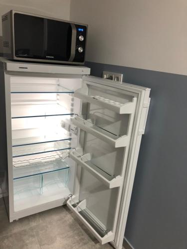 an empty refrigerator with a microwave on top of it at Pension Osthoff in Wülfrath