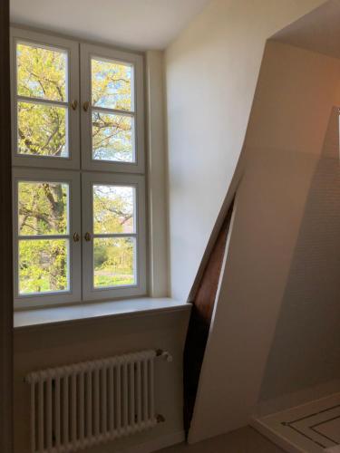 a room with two windows and a stair case at Jagdschloss Kotelow in Kotelow