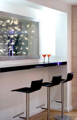 a bar with two stools and two wine glasses at Domotel Olympia in Thessaloniki