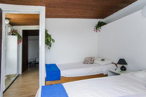 Un dormitorio con dos camas y un espejo. en House Kapetan Nono, en Drače