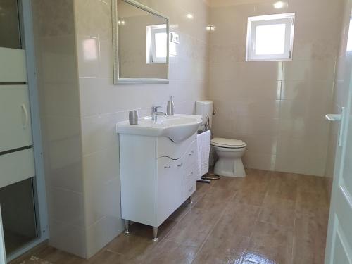 a white bathroom with a sink and a toilet at Zsigmond Vendégház in Villány