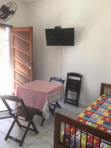 een woonkamer met een tafel en een bed bij Residencial Villa Nova in Boicucanga