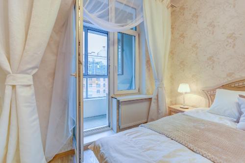 a bedroom with a bed and a large window at Апартаменты Веста в ЖК Премьер Палас in Saint Petersburg