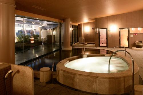 a large bathroom with a bath tub in the middle at City Plaza Osaka in Osaka
