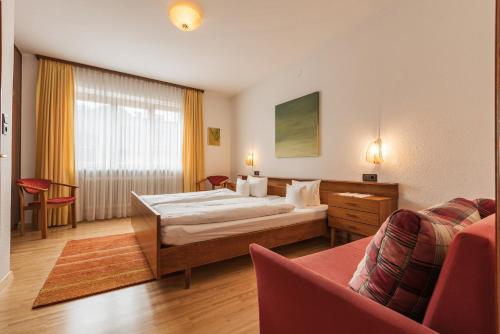 Habitación de hotel con cama y sofá en Landhaus Kreuz en Schruns