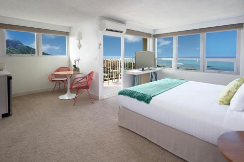 a hotel room with a bed and a table and chairs at Queen Kapiolani Hotel in Honolulu