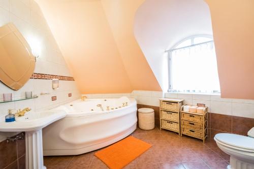 a bathroom with a large tub and a sink at Kertvárosi Családi Ház in Budapest
