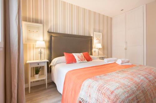 a bedroom with a large bed and two lamps at tuGuest Darro Apartment in Granada