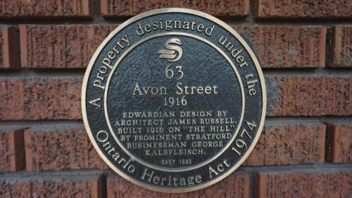 een plaquette aan de zijkant van een bakstenen muur bij Avonview Manor in Stratford