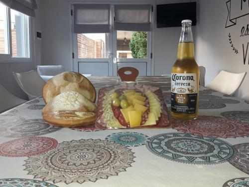 Una mesa con una botella de cerveza y algo de comida. en Vista al Parque en Tandil