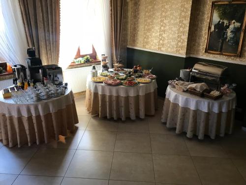 two tables with food on them in a room at Hotel Restauracja Willa Radwan in Aleksandrów Kujawski