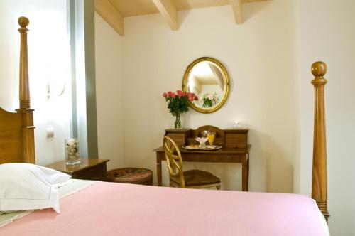 a bedroom with a pink bed and a mirror at Arhontiko Pepos in Nafpaktos