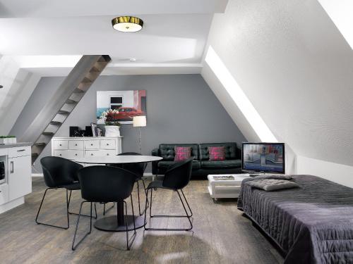 - une chambre avec un lit, une table et des chaises dans l'établissement Appartements Le 32, à Strasbourg