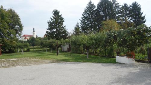 a parking lot with trees and a house in the background at Apartment Mia in Donja Pačetina
