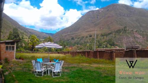 a table and chairs with a view of a mountain at Wayqi Wasi in Pisac