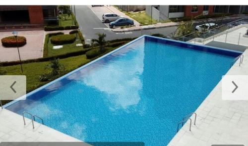 a large blue swimming pool on top of a building at Reserva del Peñon in Girardot