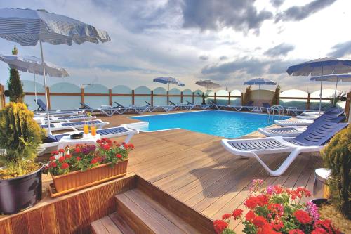 a pool with chairs and umbrellas on a deck at İstanbul Trend Hotel Old City in Istanbul