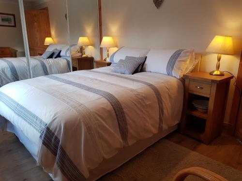 BearnockにあるLoch Ness and Highlands holiday homeのベッドルーム1室(ベッド2台、ランプ付きテーブル付)