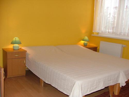 a bedroom with a white bed and two lamps at Dom Gościnny Pod Brzozami in Poznań