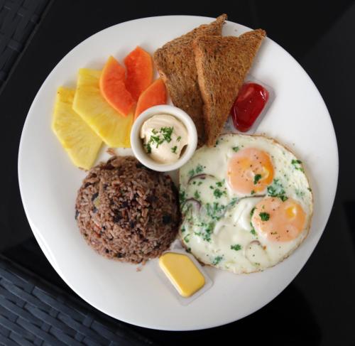 a plate of breakfast food with eggs and bread and toast at Luxury SKY PENTHOUSES 3-6BR Condo-Hotel at Oceano Jaco in Jacó